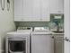Functional laundry room featuring a washer, dryer, sink, and ample cabinet space at 200 Cobblepoint Way, Holly Springs, NC 27540