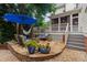 Stone patio with outdoor seating area including an umbrella, hammock, and potted plants at 200 Cobblepoint Way, Holly Springs, NC 27540