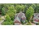 Stunning aerial view of a brick home surrounded by lush, mature trees at 2001 Dobson Ct, Raleigh, NC 27612