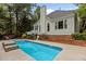 Exterior of home with beautiful backyard, inground pool, brick accents, white trim and lush landscaping at 2001 Dobson Ct, Raleigh, NC 27612