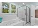 Bright bathroom featuring a large soaking tub, a glass-enclosed shower, and large window at 2001 Dobson Ct, Raleigh, NC 27612