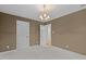 A light-filled, empty bedroom featuring large closets and chandelier lighting at 2001 Dobson Ct, Raleigh, NC 27612