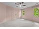 Large bedroom featuring a ceiling fan, carpeted floors, and windows offering natural light at 2001 Dobson Ct, Raleigh, NC 27612