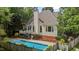 Exterior home view highlighting the in-ground pool, complemented by lush landscaping and a privacy fence at 2001 Dobson Ct, Raleigh, NC 27612
