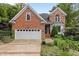 Charming red brick home boasts an attached two-car garage and beautiful landscaping at 2001 Dobson Ct, Raleigh, NC 27612