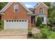 Traditional brick home featuring a two-car garage and well-maintained landscaping at 2001 Dobson Ct, Raleigh, NC 27612