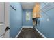 Practical laundry room with blue walls, cabinets, wire racks, and tile floors at 2001 Dobson Ct, Raleigh, NC 27612