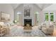 Staged living room with a fireplace, vaulted ceilings, and large windows for natural light at 2001 Dobson Ct, Raleigh, NC 27612