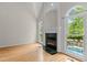 Living room featuring a fireplace, vaulted ceilings, hardwood floors and large windows with views of the pool at 2001 Dobson Ct, Raleigh, NC 27612