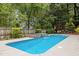 In-ground pool features a stone waterfall and patio space with outdoor seating, perfect for summer enjoyment at 2001 Dobson Ct, Raleigh, NC 27612