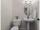 Clean powder room with pedestal sink, updated lighting, and neutral walls at 2001 Dobson Ct, Raleigh, NC 27612