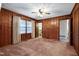 Comfortable bedroom featuring wood paneling, neutral carpet and natural lighting at 2016 Tryon Rd, Raleigh, NC 27603