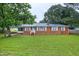Charming brick home with a well-manicured lawn, lush trees and inviting front porch at 2016 Tryon Rd, Raleigh, NC 27603