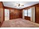 Warm living room featuring wood paneling, plush carpet and natural lighting at 2016 Tryon Rd, Raleigh, NC 27603