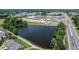 Aerial view of neighborhood with lake and sidewalks, retail shopping and roadways at 212 Hardwick St, Clayton, NC 27527