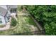 Landscaped backyard with patio, screened porch, and black metal fence bordering trees for privacy at 212 Hardwick St, Clayton, NC 27527