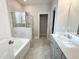 This bathroom features a bathtub, a shower, a single vanity, and tile flooring at 212 Hardwick St, Clayton, NC 27527
