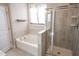 This bathroom features a bathtub, a shower, tile flooring, and a small window at 212 Hardwick St, Clayton, NC 27527