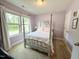 Bright bedroom featuring two windows, and a four-poster bed with light pink accents at 212 Hardwick St, Clayton, NC 27527