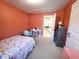 Orange bedroom with a desk, bookcase, neutral carpet, and a view into the hallway at 212 Hardwick St, Clayton, NC 27527