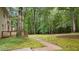 Lush backyard with a stone path leading to a wooded area, ideal for nature lovers at 220 Dalton Dr, Raleigh, NC 27615