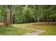 Lush backyard with a stone path leading to a wooded area, ideal for nature lovers at 220 Dalton Dr, Raleigh, NC 27615