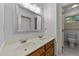 Bathroom featuring a double sink vanity with a large framed mirror and a window at 220 Dalton Dr, Raleigh, NC 27615