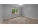 Spacious bedroom with neutral carpet, base molding, and a bright window view at 220 Dalton Dr, Raleigh, NC 27615