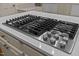 Close-up of island cooktop with stainless steel knobs and a quartz countertop at 220 Dalton Dr, Raleigh, NC 27615