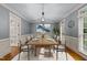 This formal dining room has a large wood table, decorative lighting, and large windows at 220 Dalton Dr, Raleigh, NC 27615
