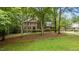 This two-story brick home has a charming yard with mature trees and landscaping at 220 Dalton Dr, Raleigh, NC 27615