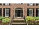 Close up of a home's brick entryway featuring a black front door with sidelights and decorative security door at 220 Dalton Dr, Raleigh, NC 27615