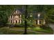 Two-story brick home with a welcoming front porch, black shutters, and professional landscaping at 220 Dalton Dr, Raleigh, NC 27615