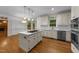 Bright kitchen with white cabinets, quartz countertops, stainless appliances, and hardwood floors at 220 Dalton Dr, Raleigh, NC 27615