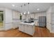 Spacious kitchen featuring stainless steel appliances, island cooktop, and hardwood flooring at 220 Dalton Dr, Raleigh, NC 27615