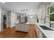 Bright kitchen with white cabinetry, center island with cooktop, and hardwood floors at 220 Dalton Dr, Raleigh, NC 27615