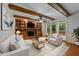Comfortable living room boasts wood beams, fireplace, built-ins, and access to an outdoor deck at 220 Dalton Dr, Raleigh, NC 27615