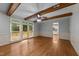 Open living room features wood beams, access to deck, hardwood floors, and entry to the kitchen at 220 Dalton Dr, Raleigh, NC 27615