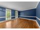 Spacious blue room with hardwood floors, white trim and bright windows overlooking backyard at 220 Dalton Dr, Raleigh, NC 27615