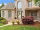 Close up of the front exterior shows beautiful landscaping, brick, and a welcoming front door at 2207 Cameron Pond Dr, Cary, NC 27519