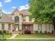 Stately brick home with beautiful landscaping, a welcoming entrance, and a large arched window at 2207 Cameron Pond Dr, Cary, NC 27519