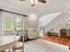 Inviting living room featuring hardwood floors, ample sunlight, and a view of the staircase at 2207 Cameron Pond Dr, Cary, NC 27519