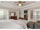 Bright main bedroom featuring tray ceilings, ceiling fan, and access to the main bathroom at 2207 Cameron Pond Dr, Cary, NC 27519