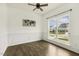 Bright dining room featuring hardwood floors, wainscoting, a modern light fixture, and a large window at 225 Rosewood Ln, Youngsville, NC 27596