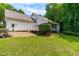 Spacious backyard with white house featuring a screened-in porch and deck, surrounded by lush greenery at 228 Birch Creek Dr, Fuquay Varina, NC 27526