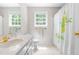 A bathroom with a white vanity and sink, a toilet, and a tub and shower with a colorful floral shower curtain at 228 Birch Creek Dr, Fuquay Varina, NC 27526