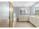 Bright bathroom with dual vanities, a soaking tub, a separate shower, and decorative wallpaper at 228 Birch Creek Dr, Fuquay Varina, NC 27526