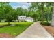 Charming home with a long driveway, surrounded by lush greenery and mature trees at 228 Birch Creek Dr, Fuquay Varina, NC 27526