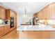 An open kitchen with light countertops, wooden cabinets and island with breakfast bar, as well as stainless steel appliances at 228 Birch Creek Dr, Fuquay Varina, NC 27526