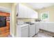 A spacious laundry room is equipped with a sink, cabinets, countertops, and a large window for natural light at 228 Birch Creek Dr, Fuquay Varina, NC 27526